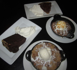 The desserts, clockwise from top: sweet potato pecan pie, freshly baked chocolate chip cookie,  warm apple crumble, chocolate blackout cake. Photo by Karen Salkin.