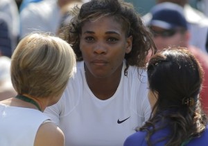 An official and a trainer talking to Serena Williams about her supposed illness at Wimbledon.