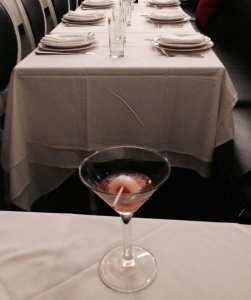 The Lychee Blossoms martini, (after Alice drank most of it!,) in front of the row of main tables.  Photo by Karen Salkin.