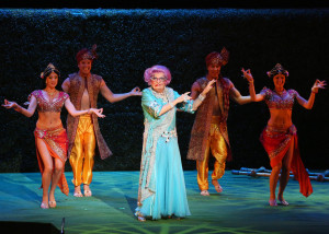 The fabulous Dame Edna, doing one of her famous scowls.  (But the dancers and background are different in this production.  And her dress is shorter!) Photo by Matt Jelonek.