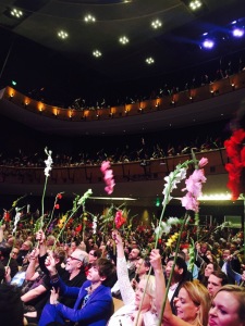 The happy opening night audience, waving their gladioli.  (And no, you don't have to bring your own!) Photo by Mr. X.