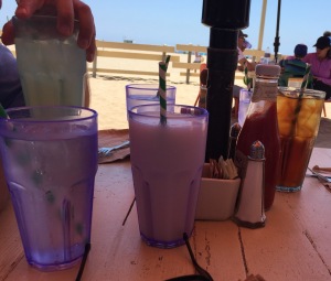 The beverages, in pretty purple glasses.  Mark's hand is clutching his lemonade n the left, and Jeanine's iced tea is on the right.  Everything in the middle is mine! Photo by Karen Salkin.