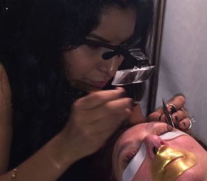 Shareen Adair applying individual lashes to a guest who's wearing their lip mask. Photo by Patty Onanagn.