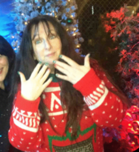 This is a still from the GIF Photo Booth.  Karen Salkin is rocking her (not) Ugly Christmas Sweater, which features a moving fireplace right under where this pic cut-off! (And showing off her holiday nails, as well.) 