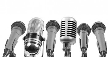 Six microphones isolated on white. The 4th from left is not a Shure mic.