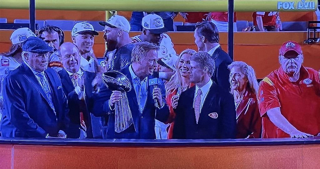 The trophy presentation, with the Chiefs' owner's creepy daughter butting in right next to the NFL Commissioner, (in the center, holding the trophy,) while the winning coach is relegated to being all the way on the end! (He's the one in red.)  And only those few players you see on the platform! Grrr.  Photo by Karen Salkin (from the TV screen.)