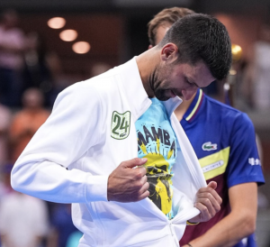 Novak Djokovic gratuitously showing his tee shirt that he hopes will link him to Kobe Bryant.