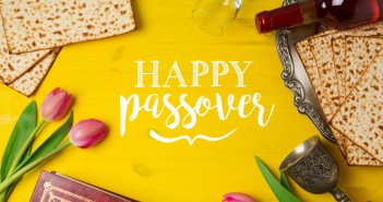 jewish-holiday-passover-pesah-celebration-with-matzoh-tulip-flowers-and-wine-bottle-on-yellow-wooden-background-view-from-above