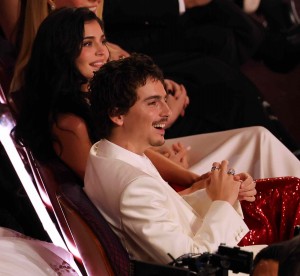 Timothee Chalamet sitting in the front row at the Oscars, enjoying jokes made at his own expense, accompanied by his girlfriend, Kylie Jenner.