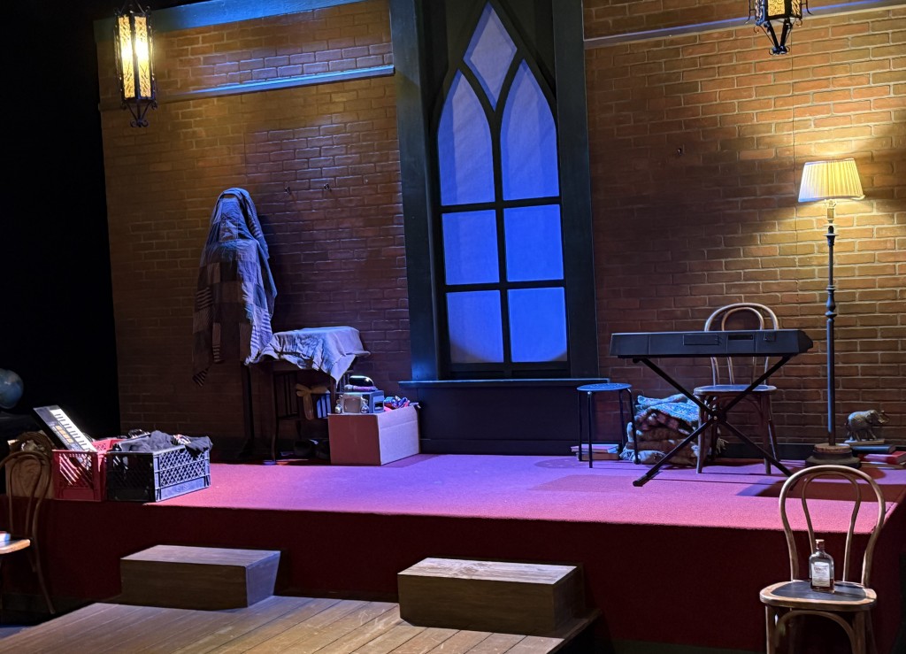 The set. Note the folded blankets next to that portable piano and chair on the upper right side. Photo by Karen Salkin.