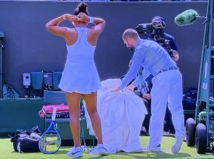 The chair referee having to move rude Naomi Osaka's bundle of crazy clothing! Photo by Karen Salkin.