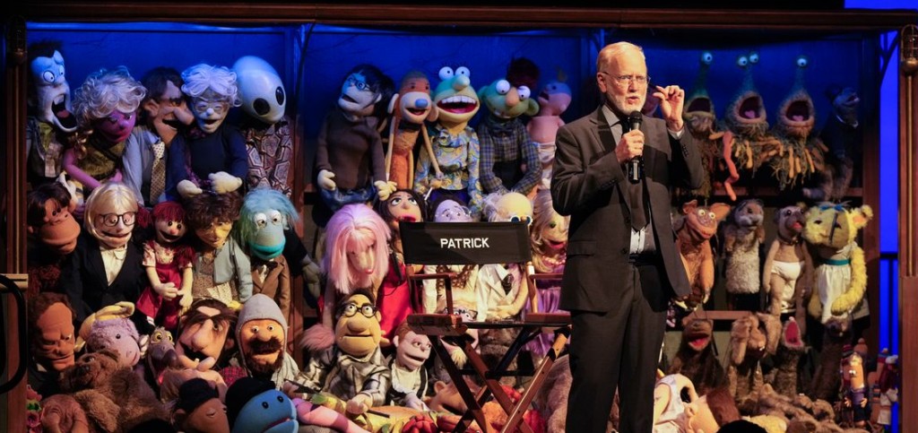 Patrick Bristow in front of the wall of puppets. Photo by Omar Gaieck.